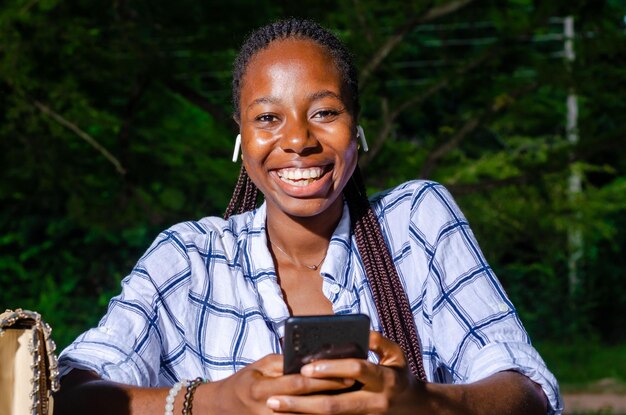 Femme afro-américaine souriante discutant sur l'application de technologie moderne pour smartphone