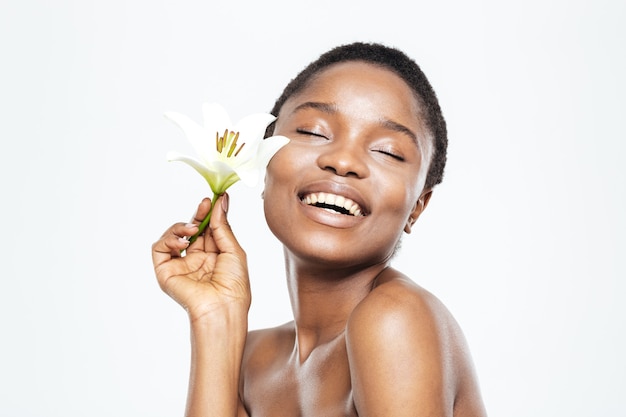 Femme afro-américaine souriante tenant une fleur isolée sur fond blanc