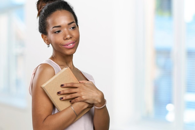 Femme afro-américaine tenant une pile de livres