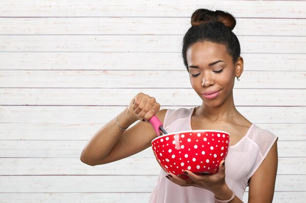 Femme afro-américaine tenant des ustensiles de cuisine