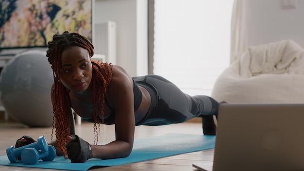 Femme afro-américaine avec des vêtements de sport étirant des exercices de yoga sur la carte de remise en forme