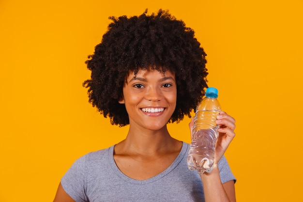 Femme afro avec une bouteille d'eau