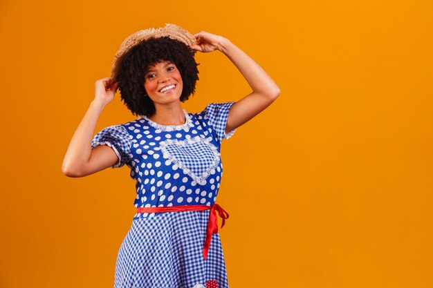 Femme afro brésilienne portant des vêtements typiques pour la Festa Junina sur jaune