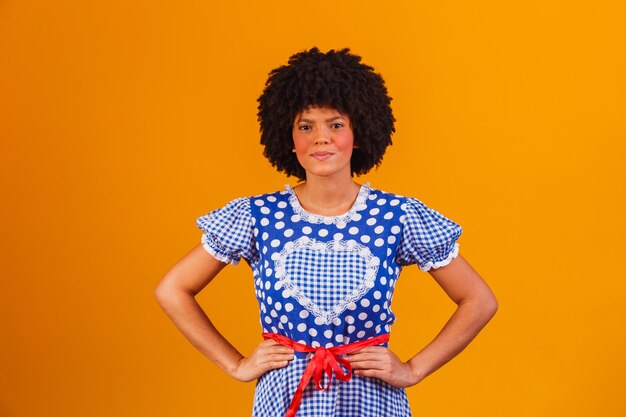 Femme afro brésilienne portant des vêtements typiques pour la Festa Junina sur jaune