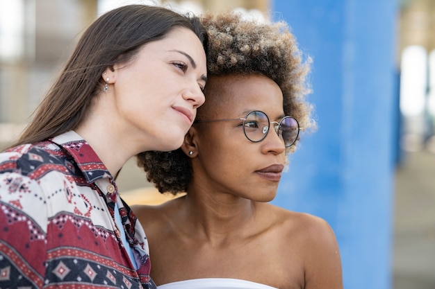 Photo femme afro et femme blanche reposant la tête l'une sur l'autre au premier plan