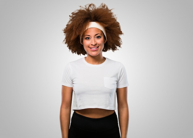 Femme afro jeune fitness debout sur blanc
