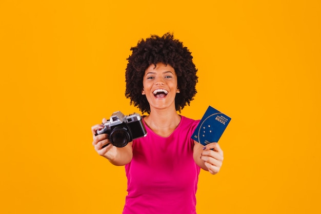 Femme afro mixte avec un appareil photo photographie et passeport brésilien