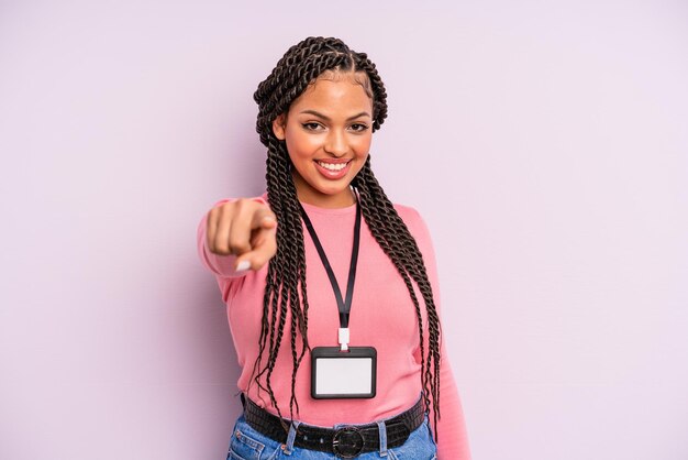 Femme afro noire pointant vers la caméra en vous choisissant une carte vip d'accréditation