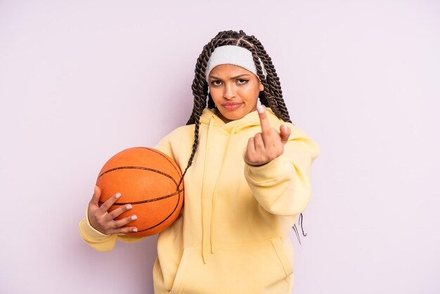 Femme afro noire se sentant en colère, agacée, rebelle et agressive. concept de basket-ball