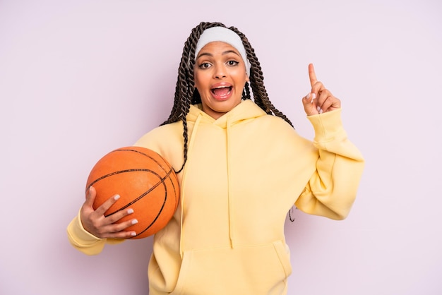 Femme afro noire se sentant comme un génie heureux et excité après avoir réalisé une idée. concept de basket-ball