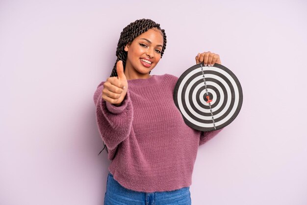 Femme afro noire se sentant fière de sourire positivement avec le concept de fléchette cible