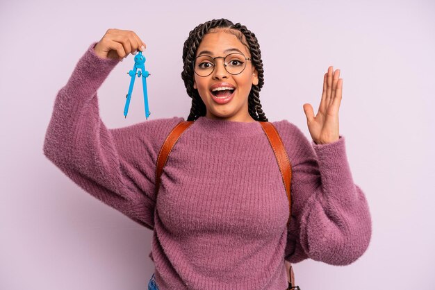 Femme afro noire se sentant heureuse et étonnée de quelque chose d'incroyable. boussole de mesure concept étudiant