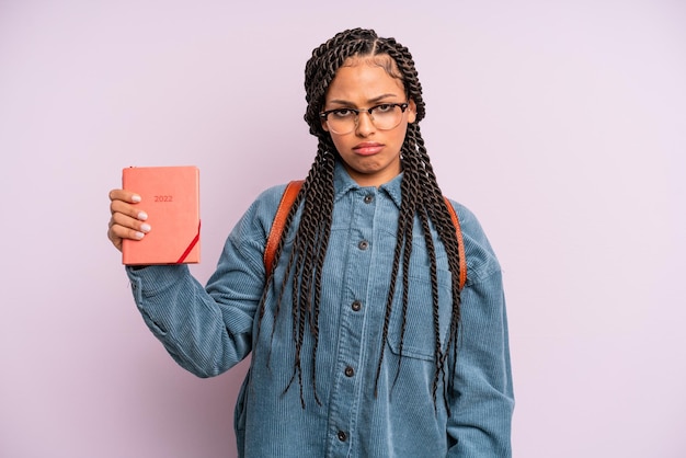 Femme afro noire se sentant triste, contrariée ou en colère et regardant sur le côté. calendrier étudiant ou concept d'agenda