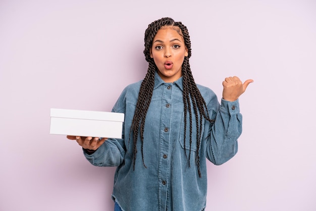 Femme afro noire semblant étonnée d'incrédulité. concept de boîte de colis