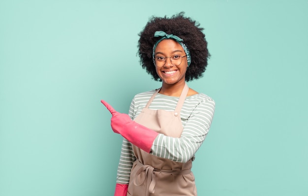 Femme afro noire semblant excitée et surprise pointant vers le côté et vers le haut pour copier l'espace. concept de ménage.. concept de ménage