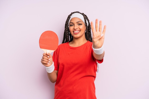 Femme afro noire souriante et amicale montrant le concept de ping-pong numéro quatre