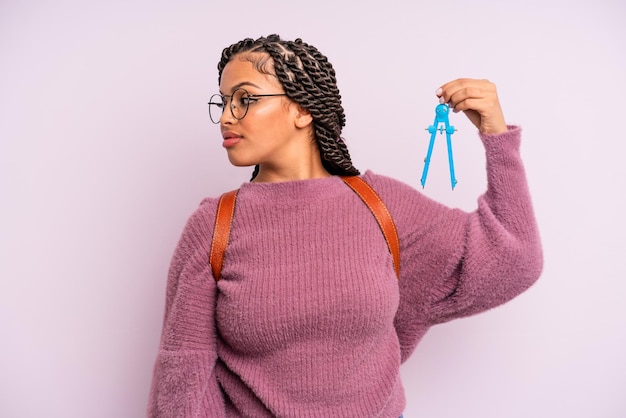Femme afro noire sur la vue de profil pensant imaginer ou rêvasser mesure boussole concept étudiant
