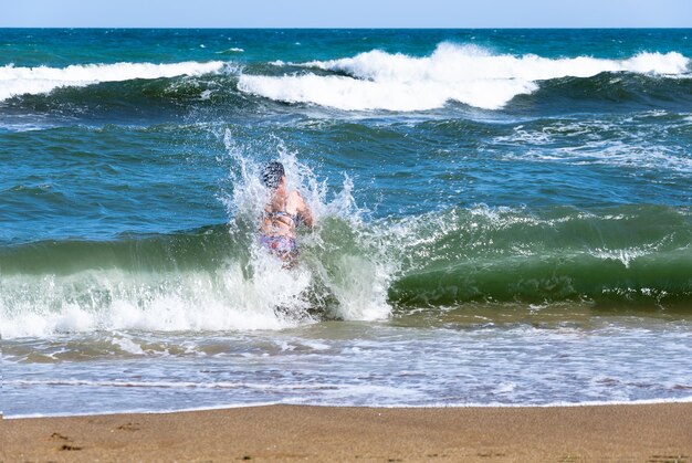 Une femme d'âge mousse sort de la mer