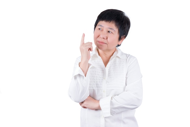 Femme d'âge moyen asiatique en chemise blanche pointant le doigt et pensant isolé sur fond blanc