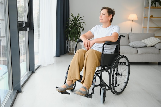 Femme d'âge moyen assise sur un fauteuil roulant