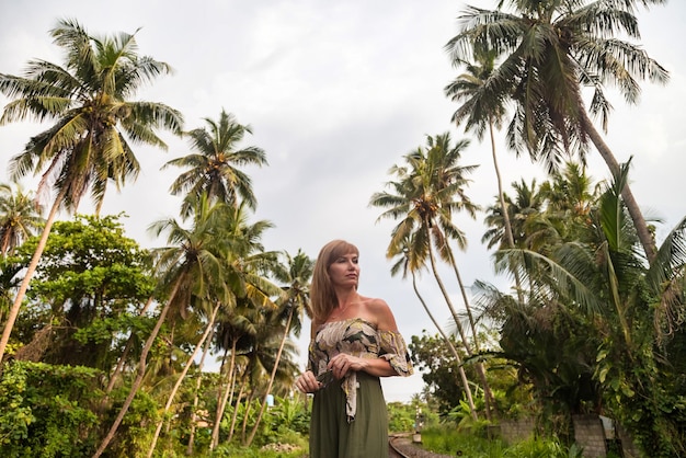 Femme d'âge moyen au Sri Lanka à l'arrière-plan de la jungle tropicale à la recherche de suite