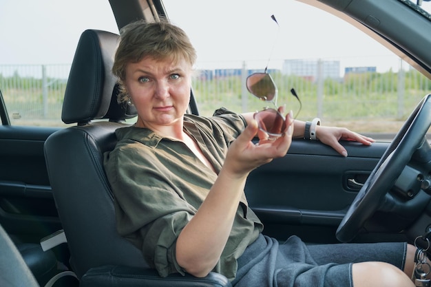 Une femme d'âge moyen au volant d'une voiture exprime son mécontentement