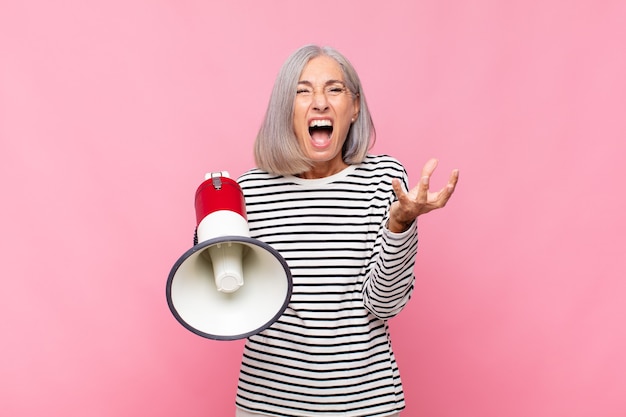 Femme D'âge Moyen à La Colère, Agacé Et Frustré Hurlant Wtf Ou Quel Est Le Problème Avec Vous Avec Un Mégaphone