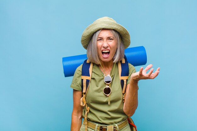 Femme d'âge moyen à la colère, agacée et frustrée crier wtf ou ce qui ne va pas avec vous