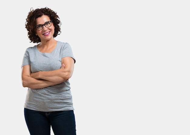 Femme d&#39;âge moyen croisant les bras, souriante et heureuse, confiante et amicale