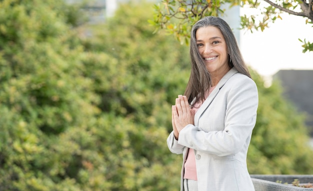 Une femme d'âge moyen fait du yoga dans la rue