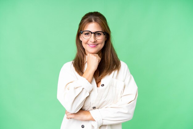 Femme d'âge moyen sur fond isolé avec des lunettes et souriant