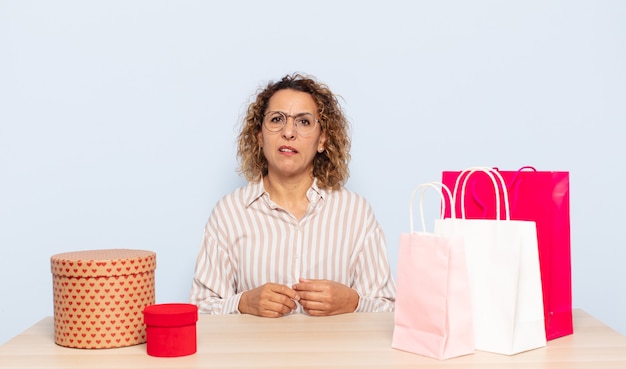 Femme d'âge moyen hispanique se sentir perplexe et confus, avec une expression stupide et stupéfaite en regardant quelque chose d'inattendu