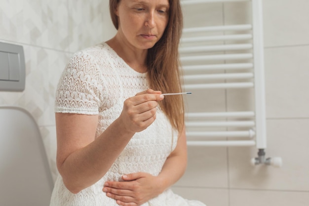 Femme d'âge moyen inquiète avec test de grossesse