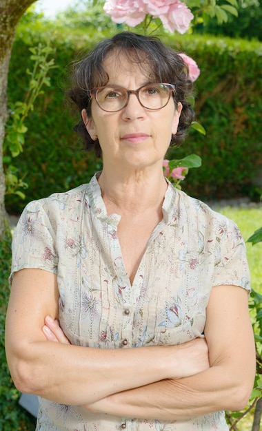 Femme d'âge moyen avec des lunettes dans le jardin