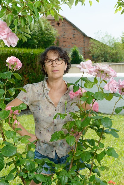 Femme d'âge moyen avec des lunettes dans le jardin