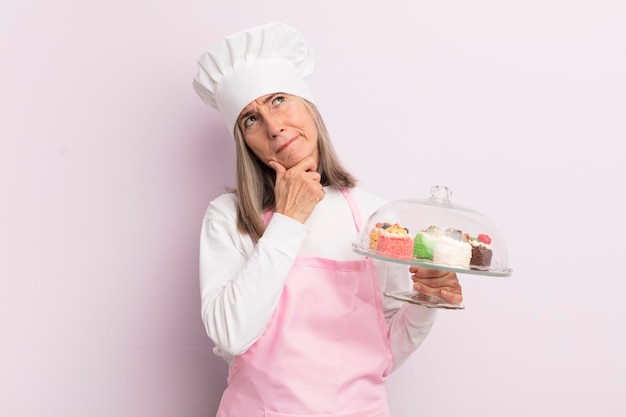Femme d'âge moyen pensant se sentir douteuse et confuse concept de boulanger et de gâteaux