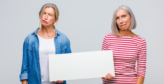 Femme d'âge moyen à la perplexité et à la confusion, mordant la lèvre avec un geste nerveux, ne sachant pas la réponse au problème