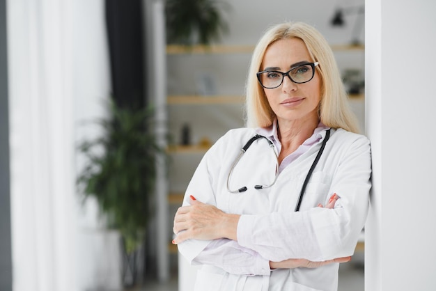 Femme d'âge moyen portant l'uniforme de médecin à la clinique