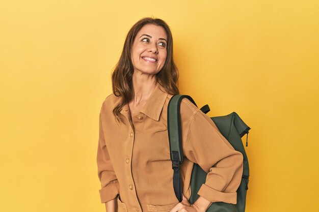 Femme d'âge moyen préparée à la randonnée photo de studio jaune rêvant d'atteindre des objectifs et des buts