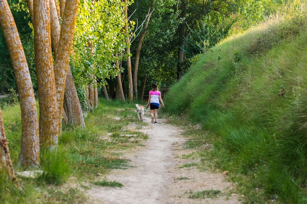 Femme d'âge moyen qui marche avec son chien sur un sentier de montagne