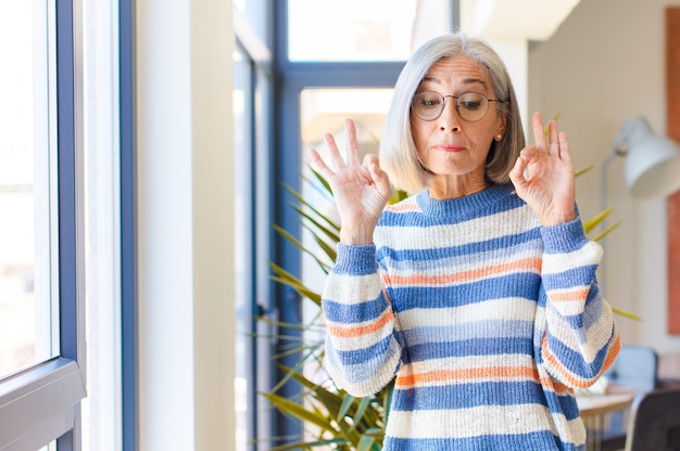 Femme d'âge moyen à la recherche concentrée et méditant