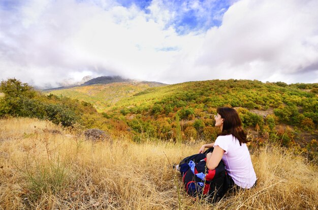 Femme d'âge moyen se reposant sur l'herbe dans la zone de montagne