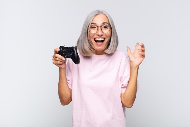 Femme d'âge moyen se sentant heureuse, excitée, surprise ou choquée, souriante et étonnée de quelque chose d'incroyable