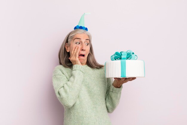 Femme d'âge moyen se sentant heureuse excitée et surprise concept de gâteau d'anniversaire