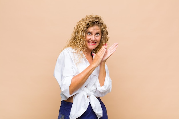 Femme d'âge moyen se sentant heureuse et réussie, souriant et applaudissant, disant félicitations avec applaudissements