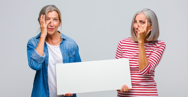 Femme d'âge moyen se sentir ennuyé, frustré et somnolent après une tâche ennuyeuse, terne et fastidieuse, tenant le visage avec la main