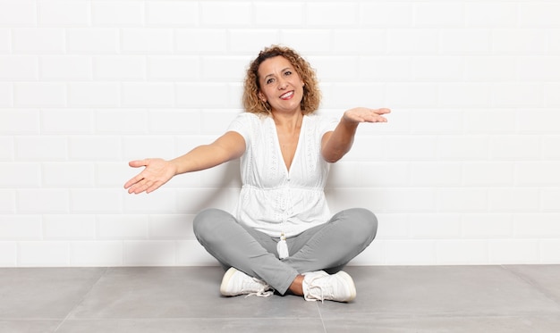 Femme d'âge moyen souriant joyeusement donnant un câlin de bienvenue chaleureux, amical, aimant, se sentant heureux et adorable