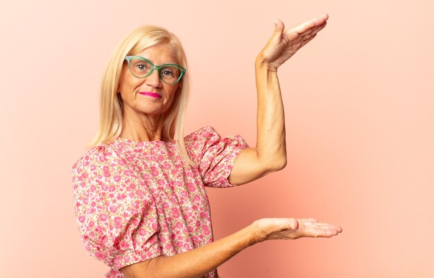 Femme d'âge moyen souriant joyeusement avec un regard amical, confiant et positif isolé