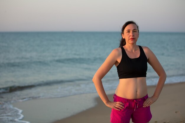 Femme d'âge moyen en tenue de sport sur fond de mer