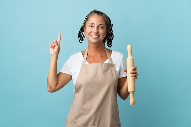 Femme d'âge moyen en uniforme de chef pointant vers le haut une excellente idée